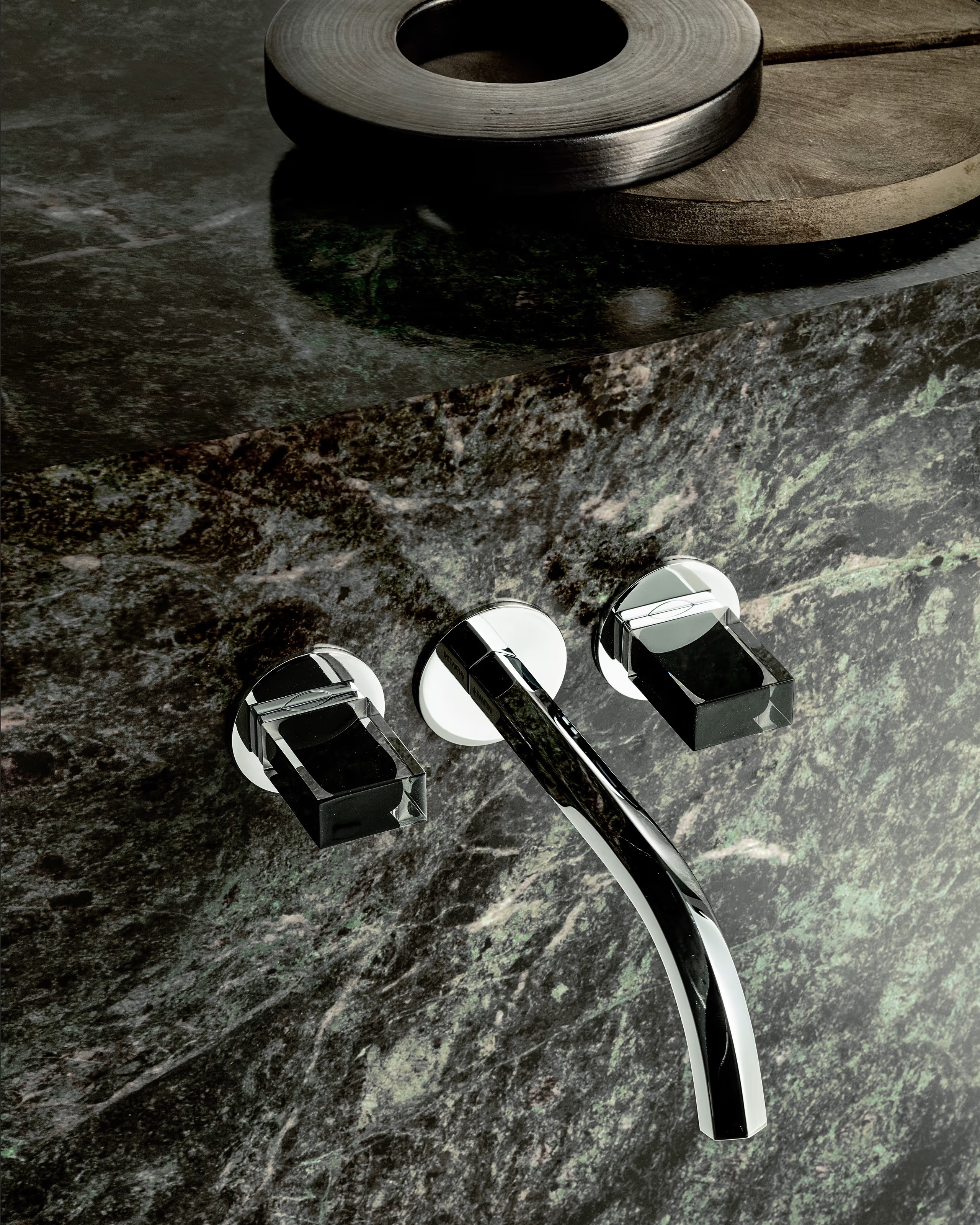 Chrome wall-mount faucet on green marble